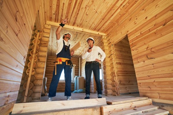 Worker showing part of house to civil engineer